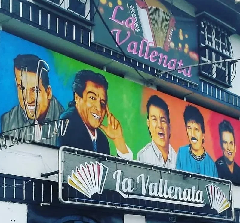 Fachada real de La Vallenata en Bogotá con sus murales de cantantes